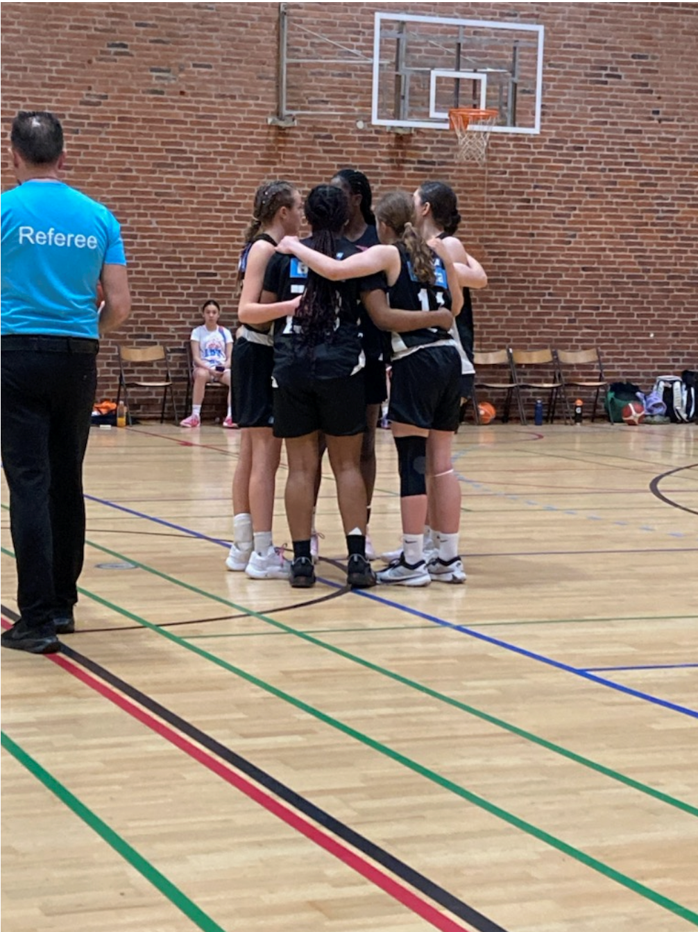 Piger krammer hinanden på basketballbanen