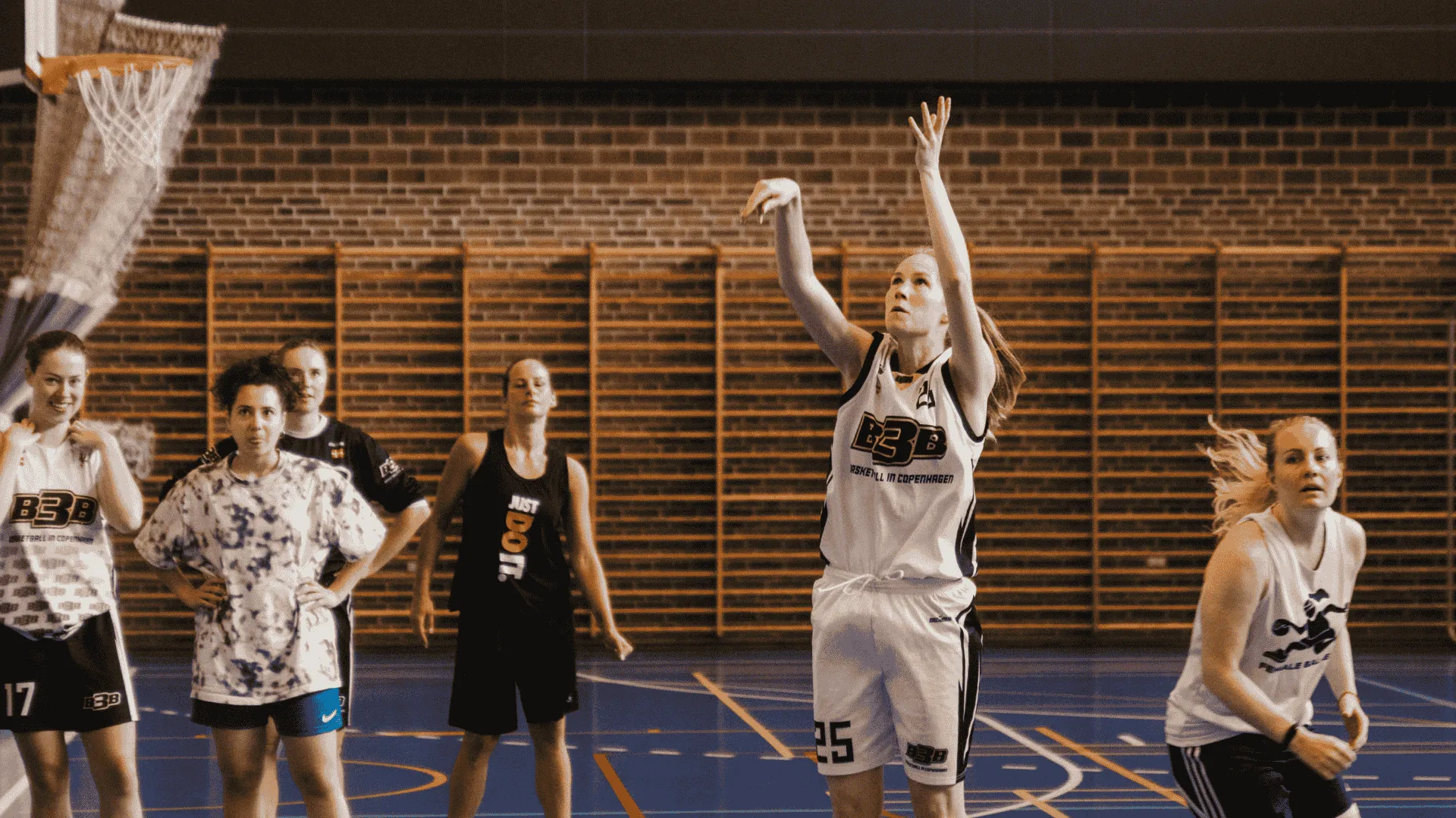 Kvinder hopper op og dunker basketbold i kurven hos B3B, B3B er medlem af DGI Østjylland